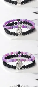 Conjunto de pulseras de cuentas de ágata morada agrietada y negras con colgante de flor.