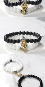 Closeup details of black white beaded couple bracelets with magnetic handshake clasp design.
