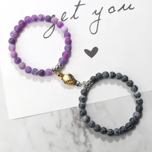 Magnetic handshake couple bracelet with purple and black cracked agate beaded designs.