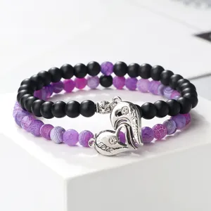 Matching magnetic couple bracelets with matte black and purple cracked beads and heart charms.