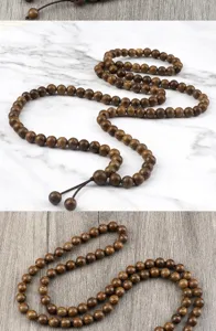 Detailed shot of dark wooden beaded necklace and bracelet, natural texture and vintage style.