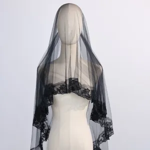 Close-up detail of the black lace bridal veil, showing delicate embroidered floral edges.
