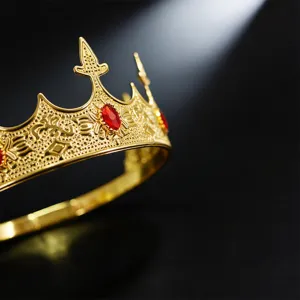 Exquisite gold crown with red gemstones detail view for royal wedding party costumes.