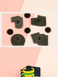 Close up of retro camera and film enamel brooch pin, alloy metal fashion accessories.