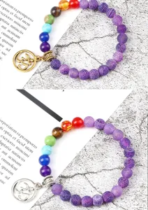 Detailopname van chakra steen armbanden met Om hanger en kleurrijke kralen, macro.