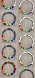 Vue détaillée de bracelets de chakra en pierre naturelle avec perles colorées sur fond de bois.