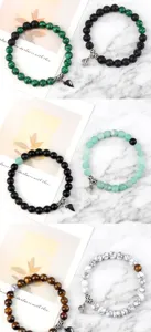 Detailed view of fashion couple beaded bracelets with magnetic heart charms and natural stone beads.
