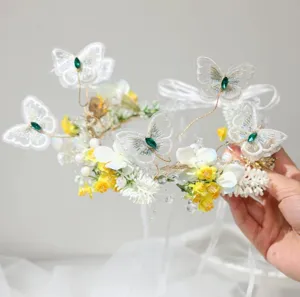 Gros plan détaillé de la couronne de fleurs papillon brodée elfe avec cristaux verts.