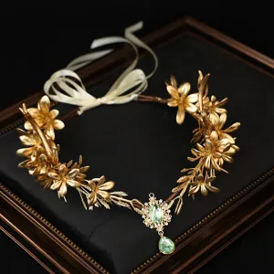 Détail du diadème de vigne à feuilles dorées fait main avec pendentif en cristal vert et ruban.