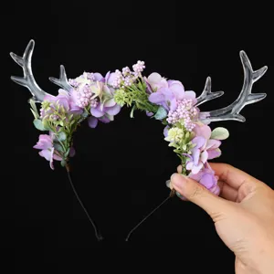 Detail view of a forest style purple flower headband with clear acrylic deer antlers, fairy elf headwear.