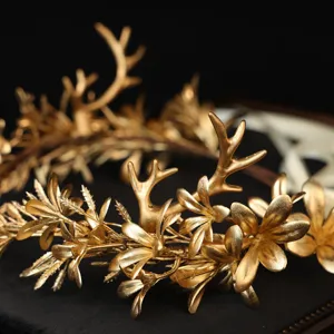 Détail de couronne de cheveux bois feuille dorée, tiare de mariée style forêt de fées.