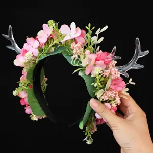 Floral reindeer antler headband detail showing pink flowers, green leaves, and clear acrylic antlers.
