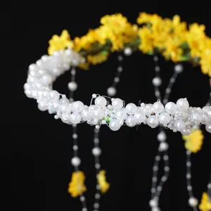 Pearl daisy tassel floral crown hair accessory detail shot, elegant bridal and vacation style.
