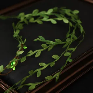 Detaillierte Nahaufnahme eines waldgrünen Blatt-Ranken-Haarbandes mit kleinen Frucht-Details.