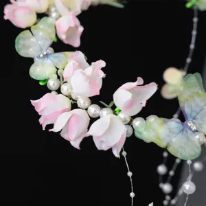 Handmade bridal hair garland with faux pearls and fabric butterflies for wedding styling.