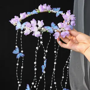 Close-up of handmade butterfly flower hair crown with pearl tassels, ideal for bridal wedding styling.