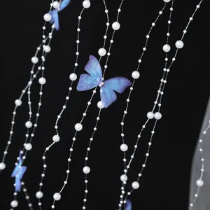 Close-up detail of bridal hair accessory featuring handmade pearls and blue butterflies.