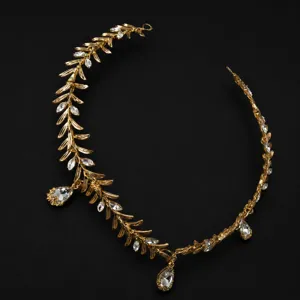 Gros plan détaillé du serre-tête doré en forme de feuille d'olivier avec des strass.