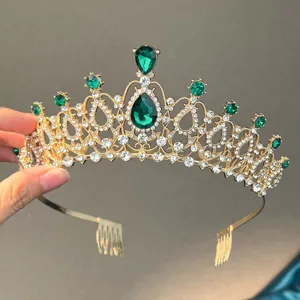 Detailed view of gold bridal tiara with green rhinestones and hair combs for wedding accessory.