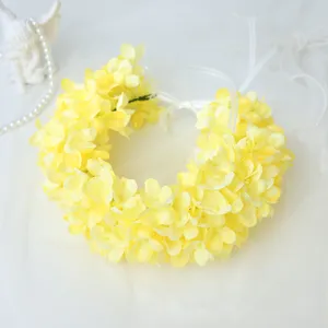 Detailed view of yellow artificial hydrangea flower crown close-up, bridal wedding hair accessory.