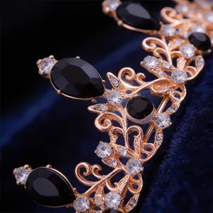 Gros plan sur un diadème de mariée or rose avec des strass noirs en forme de larmes et cristaux.