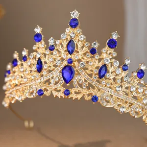 Detailed close-up of gold rhinestone crown tiara with blue gemstones for bridal wedding hair.
