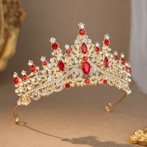 Close-up detail of luxurious gold tiara sparkling with vibrant red rhinestones and clear crystals.
