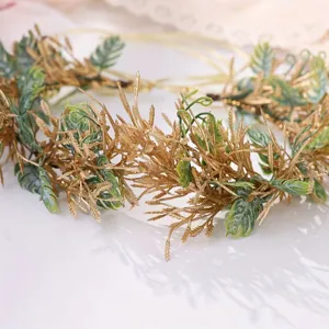 Close-up detail view of the golden green leaf vine hairband, perfect for forest style photos.