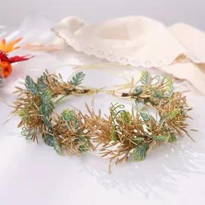 Detail view of a gold and green vine flower crown headband for party and photography.