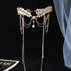 Detalle de diadema de novia dorada con hojas de pedreria y borlas para accesorios de boda.