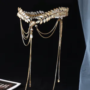 Detalle de tocado nupcial hojas strass dorado, cadena de pelo borla cristal para boda.