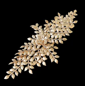 Gold bridal hair accessory featuring intricate leaf patterns and sparkling rhinestones.