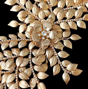 Close-up of golden bridal hair accessory with intricate leaf details and sparkling rhinestones.