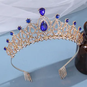 Gold rhinestone bridal tiara detail, featuring blue crystal stones and secure hair combs.