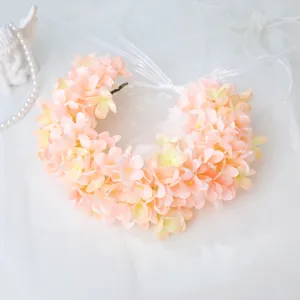 Close-up detail of the pink artificial hydrangea floral wreath with delicate white ribbon ties.