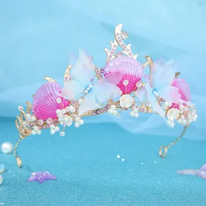 Detail shot of ocean style tiara featuring pink shells, blue butterflies and pearls.