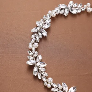 Detail shot of bridal rhinestone and faux pearl leaf headband, sparkling crystal hair accessory.