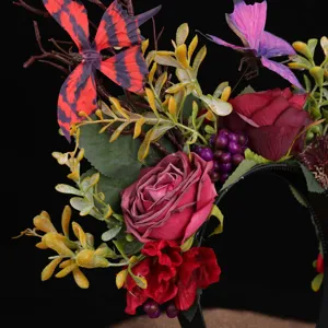 Nahaufnahme des gotischen Blumen-Haarreifs mit roten Rosen, Schmetterlingen und Beeren.