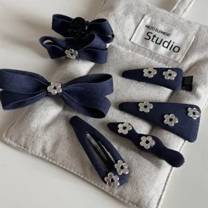 Detailed view of cute denim blue bow hair clips and metal flower hairpins for cute styles.