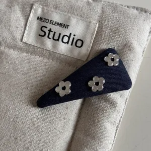 Denim blue hair clip featuring silver flower studs, chic triangle design for stylish daily hairstyles.