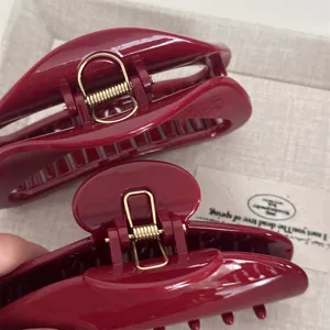 Red acrylic hair claw clip with metallic spring for women daily styling and hair accessories.