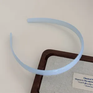 Light blue plastic headband detail showing teeth design, smooth texture, minimalist hair accessory.