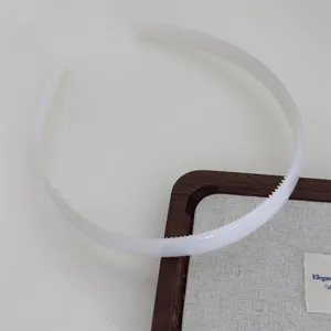 Clear detail view of the white plastic teeth hair hoop, simple design for daily wear.