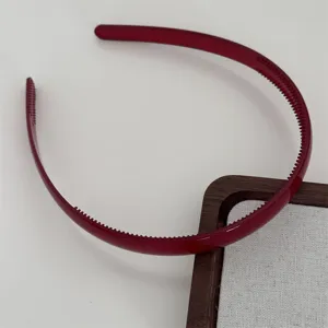 Close-up detail shot of dark red plastic hair hoop with teeth designed for daily styling use.
