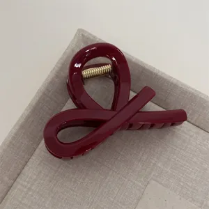 Red minimalist abstract geometric hair claw clip detail shot, elegant daily styling accessory.