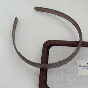 Detailed view of a translucent brown plastic hairband with teeth for daily washing face and styling.