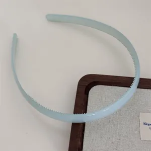 Detail view of light blue plastic hair hoop with teeth, translucent jelly style for daily wear.