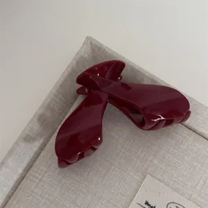 Burgundy hair claw clip detail, elegant gloss finish shark clip for thick hair styling.