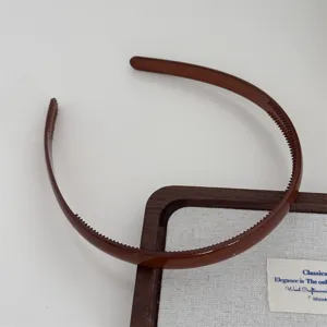 Brown plastic toothed hair band detail view, minimalist daily hair accessory for women.