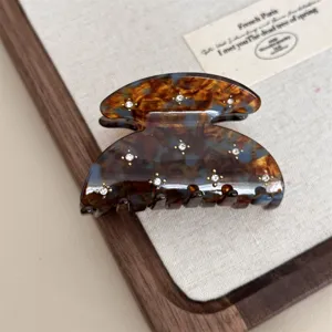 Detailed shot of retro tortoise shell hair claw clip with sparkling rhinestones.